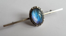 Antique silver bar brooch with butterfly wing in a domed silver setting.