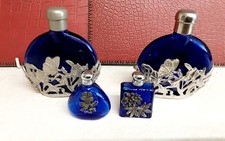 COLLECTION OF FOUR BLUE GLASS PERFUME BOTTLES WITH FILLIGREE PLATED DECORATION