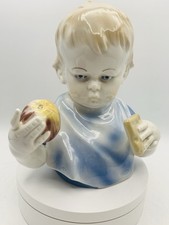 Metzer Ortloff Porcelain bust of a child with bib, holding an apple and biscuit 