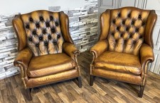 A pair of antique  leather chesterfield Queen Anne high back chairs in tan