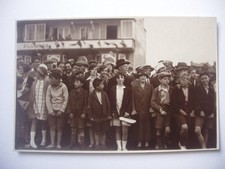Crowd of spectators on pavement , probably watching Whitstable Carnival