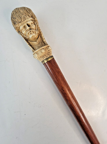 Carved composite man face - man, cane