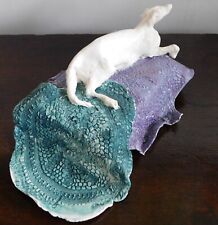 Whippet lying on a bed: a contemporary sculpture in porcelain by Jacqueline Sell