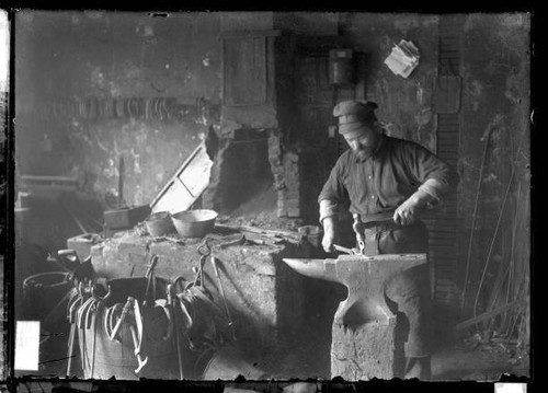 Blacksmith hammering an - blacksmith,
