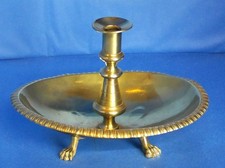 A Victorian brass candlestick in a large drip bowl. 26cms wide