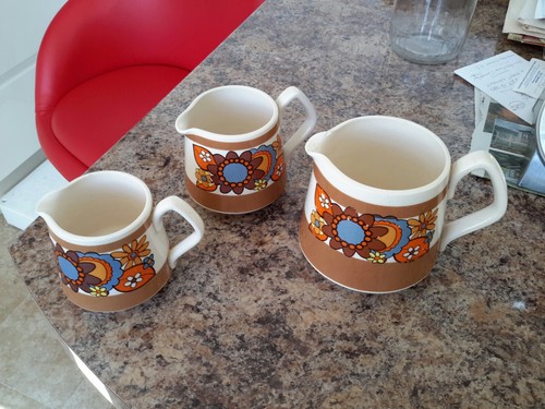 Three matching decorated jugs - three,