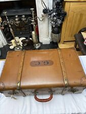 A brown 20thC trunk, with teak straps, leather handles 66-40-24