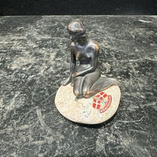Sculpture of mermaid on rock