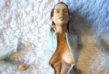 A Plastic Erotic Figure of a Woman Bursting out of her Jumpsuit - 2 Figures