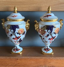 PAIR OF COALPORT HONG KONG LIDDED URNS / VASES WITH GILT RAM HEAD HANDLES.. 