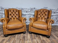 A pair of Tetrad Oskar  tan leather chesterfield wing chairs very sought after