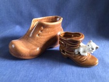 ￼Two pottery boots  one with the cat