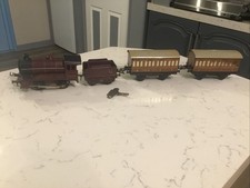 A VINTAGE HORNBY CLOCKWORK “O” GAUGE TRAIN & CARRIAGES. GWO.