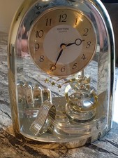 Rhythm Quartz Spinning Pendulum Mantle Clock Analogue, Battery, Gold Tone
