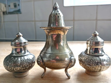 Vintage ornate silver plated pepper pot trio.