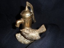BRASS WREN SITTING BY A WATER PUMP