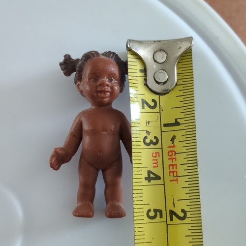 Tiny brown rigid plastic doll - brown,