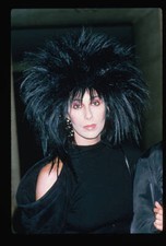 Cher in a black wig and dress