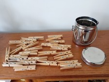 Chrome / stainless steel clothes peg caddy full of new pegs. With handle.