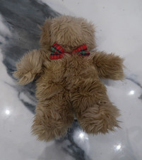 Hairy brown teddy bear with bead eyes and a red and green bow tie.