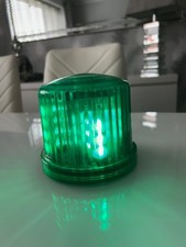 Flashing beacon in green with LEDs and magnetic base for vehicle roof.