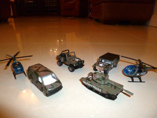 4 Small army vehicles and 2 helicopters. Camouflaged and most with Military Poli