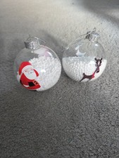 2 Clear Baubles Filled With Polystyrene Balls With a Santa And Reindeer Design
