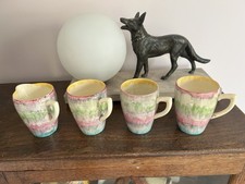 3 x CLARICE CLIFF HANDLED BEAKERS WITH MATCHING CREAM JUG