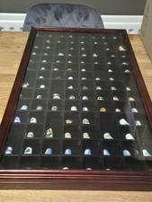 COLLECTION OF 100 THIMBLES IN A LARGE GLASS FRONTED DISPLAY CABINET.