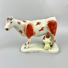 A Victorian pearlware Staffordshire Cow Creamer, with milkmaid, c1840.