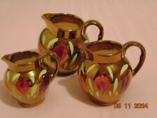 Old Court Ware. Set 3 Graduated Jugs. Gold Coloured Lustre. Floral Pattern