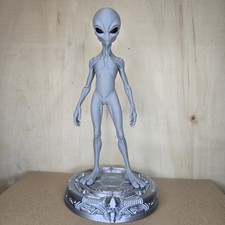 grey alien figurine on a stand