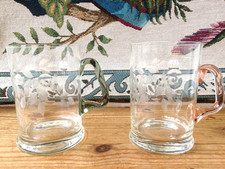 PAIR of CLEAR CUT GLASS TANKARDS (with Leaf decoration and coloured handles)