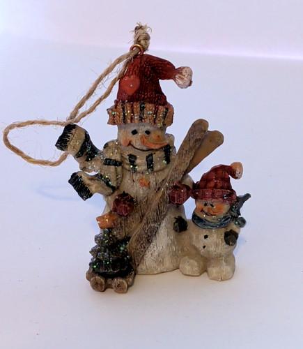 Snowman taking his son skiing - his,
