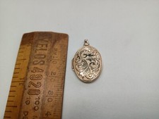 9 carat yellow gold hallmarked oval locket,engraved to front weighing 1.8gms.