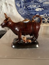 19th Century Treacle Glazed Staffordshire Cow Creamer with Seated Dog C.1820