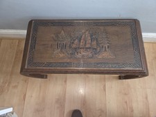 Oriental carved wood coffee table with a glass top.