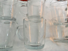 Six large glass cappuccino or other coffee mugs with handles.