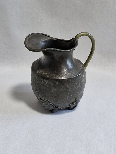 Small dark metal jug possibly - dark,