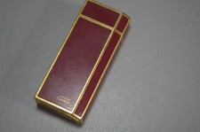 VINTAGE  MUST DE CARTIER LIGHTER  IN GOLD AND DARK RED ENAMEL.