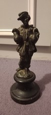 small antique bronze of a peasent holding 2 ducks