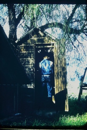 Man using the outhouse with - using,