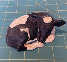 Fresian calf cow laying down made by Lakeland Fine Arts