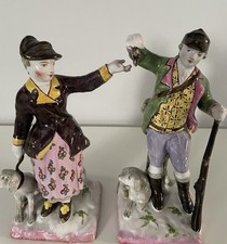 A Pair of Brightly Coloured 19th Century Faience Hunting Figures with Dogs