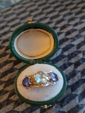 2 Triple Rated Tanzanite Stones Surrounding A Topaz Centre Stone.