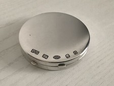 A VINTAGE SOLID SILVER COMPACT WITH OSTENTATIOUS HALLMARKS WITH MIRROR AND PAD.
