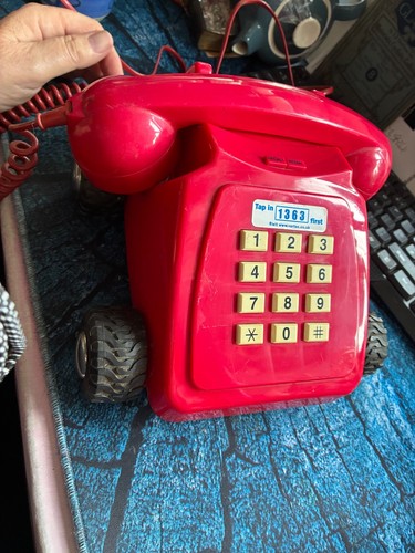 Red telephone with wheels - telephone,