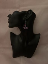 The pink and black fuse bead earrings are  displayed on a mannequin head.       