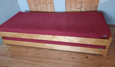 FUTON stacking occasional guest beds with FUTON mattress and dark red covers 