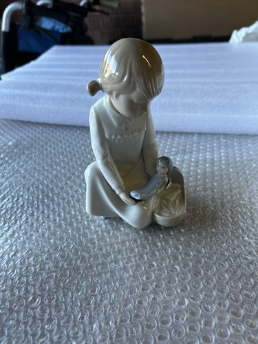 Nao girl sitting holding doll - sitting,